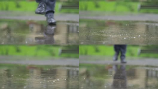 一个穿着黑鞋的男人踩进水坑里，慢镜头180帧/秒高清在线视频素材下载