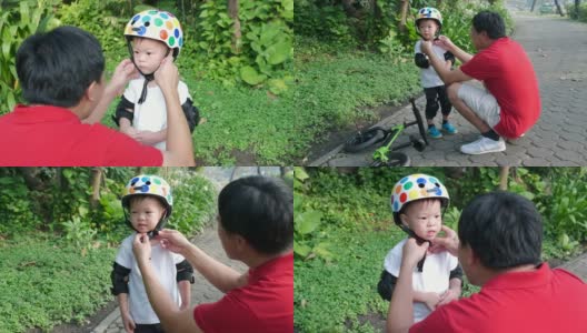爸爸给2岁的亚洲小孩戴上护膝，爸爸和儿子在公园里玩平衡自行车(跑步自行车)高清在线视频素材下载
