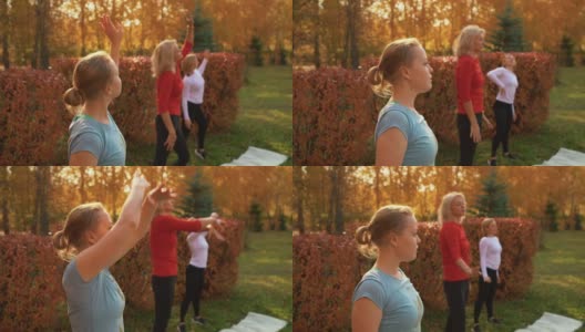 女舞者在秋季公园训练编舞。健身妇女在城市公园的户外课跳舞。瑜伽团体在户外练习De Bras港。高清在线视频素材下载
