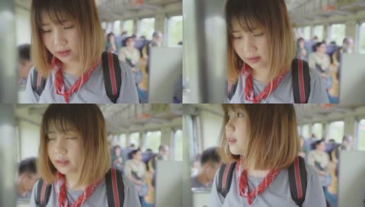 一名亚洲女子在坐火车时边走边找座位。高清在线视频素材下载
