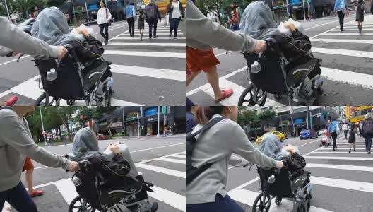 年轻女子推着轮椅上的老妇人过马路高清在线视频素材下载