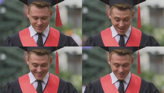 惊讶的男毕业生低头微笑着面对，事业机会高清在线视频素材下载