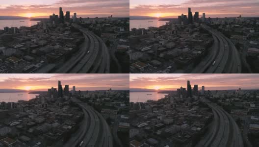 直升机鸟瞰城市与日落在山地平线辉映在海水上高清在线视频素材下载