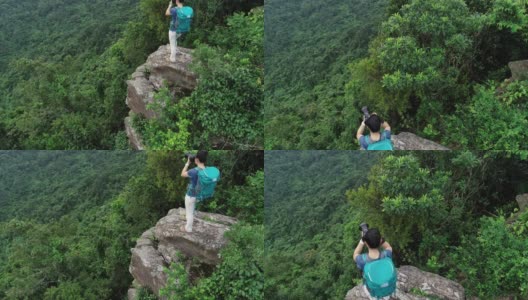 航拍的女性摄影师在热带森林徒步旅行时拍照高清在线视频素材下载