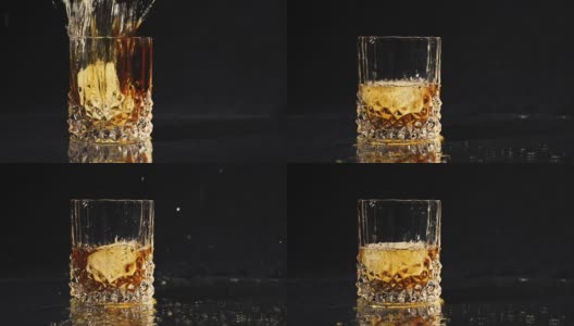 冰块落入威士忌杯中，以慢动作溅起水花。高清在线视频素材下载