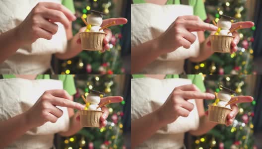 特写镜头:为冬天传统节日圣诞节准备烘焙糕点食品和甜点摊，在晚上在厨房里用้手工添加一个黄色按钮和黄色按钮形状的巧克力自制纸杯蛋糕做一个雪人高清在线视频素材下载