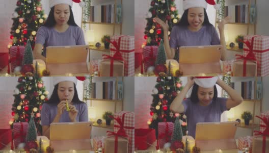 亚洲妇女使用平板电脑会议和视频电话在线在家里与圣诞树装饰节日的背景。圣诞节庆祝活动的概念。4 k慢动作。高清在线视频素材下载