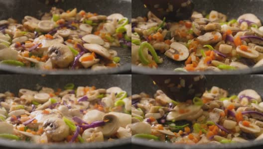 慢动作翻炒，炒蘑菇，洋葱，胡萝卜，大蒜和黑胡椒高清在线视频素材下载