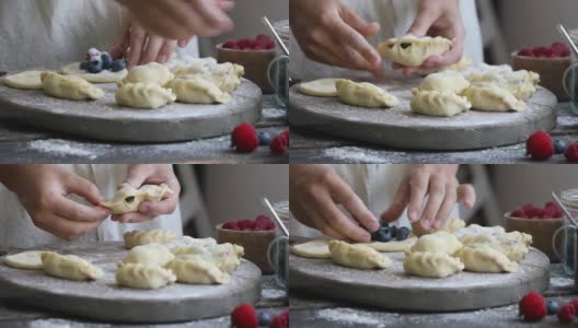 一位妇女用面粉在木制背景上自制了一个饺子或Pierogi。传统的乌克兰或波兰食物。高清在线视频素材下载