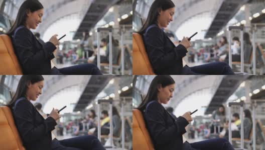 一个女人在机场用智能手机高清在线视频素材下载