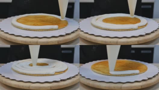 一个糕点袋把白奶油挤在一个薄薄的海绵蛋糕上，形成一个圆圈高清在线视频素材下载
