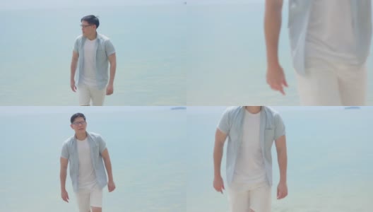 一名戴着眼镜的英俊青年带着一种孤独和失望的表情走在海滩上高清在线视频素材下载