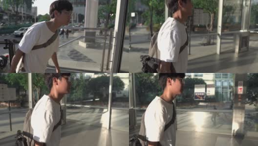 一名男子背着电动滑板车在地铁站里。侧视图高清在线视频素材下载
