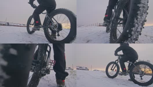 职业极限运动员骑着一辆胖胖的自行车坐在户外。骑自行车的人斜倚在冬天的雪林里。带着头盔和眼镜的大轮胎骑山地车的人。慢动作，180fps。高清在线视频素材下载