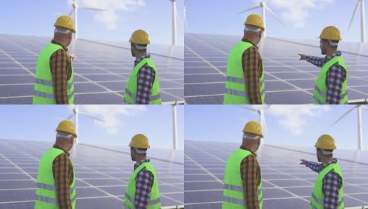 在太阳能发电站的工人-太阳能板与风力涡轮机背景-绿色能源可再生的概念高清在线视频素材下载