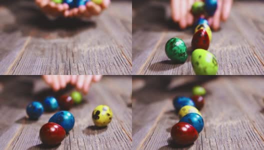 复活节滚彩蛋。近距离的视频，彩色的鸡蛋滚动在木制桌子上的手。节日装饰高清在线视频素材下载