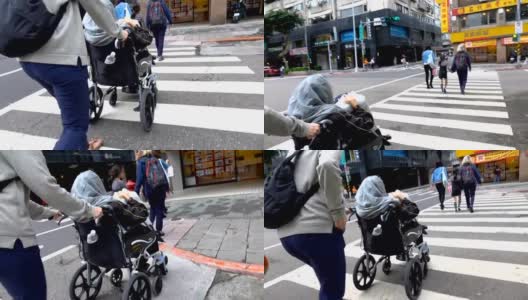年轻女子推着轮椅上的老妇人过马路高清在线视频素材下载