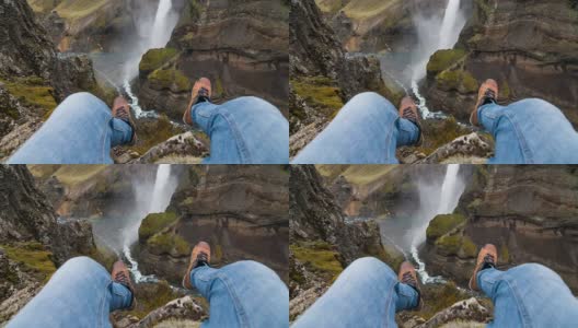 人的个人视角在他的脚上摇摆，坐在峡谷的边缘高清在线视频素材下载