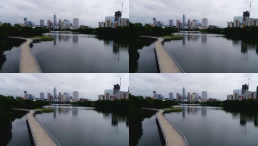 在滨河行人桥上的城镇湖空的不祥的一天，无人机的视图与市中心天际线城市景观桥的右上方高清在线视频素材下载