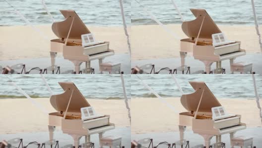 大钢琴以大海为背景，白色大钢琴站在沙滩上，婚礼在沙滩上举行，概念高清在线视频素材下载