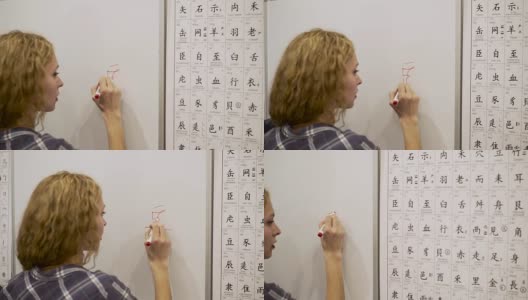 一名年轻女子用记号笔在白板上写象形文字高清在线视频素材下载