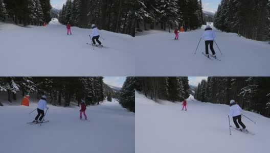 两个运动女子滑雪者在山上滑雪在森林下坡高清在线视频素材下载