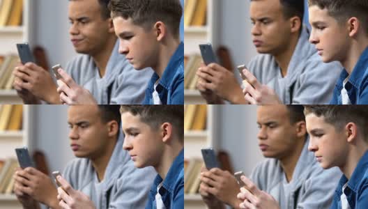 两个高中好友在智能手机上玩手机游戏，周末休闲高清在线视频素材下载