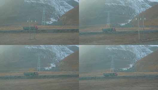 慢镜头:从移动的火车上看到一辆卡车在西藏运输货物。高清在线视频素材下载