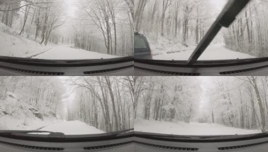 汽车POV在积雪覆盖的路上行驶，先下起了雪。高清在线视频素材下载