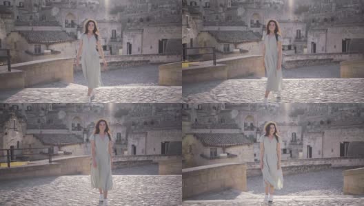 美丽优雅的年轻女子走在意大利马泰拉古城高清在线视频素材下载