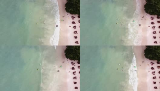 泰国的桑德岛。鸟瞰图，一群人在附近的海边玩耍。在海滩上的餐厅桌子上和人们嬉戏。高清在线视频素材下载
