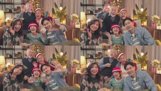 笑容满面的亚洲大家庭和孩子们坐在客厅的沙发上一起在手机上自拍视频，快乐的父母和孩子们在家里用智能手机进行有趣的视频通话高清在线视频素材下载