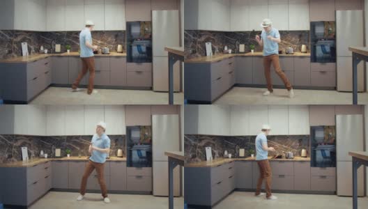 一个戴着帽子的男人在厨房边做饭边跳舞唱歌，手里拿着勺子高清在线视频素材下载
