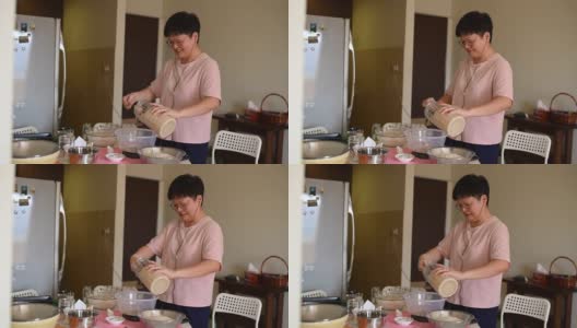 一个亚洲华人在家做母亲准备面团高清在线视频素材下载
