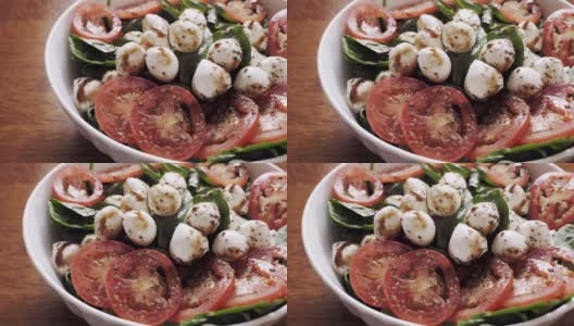 一份健康的卡普里沙拉，菠菜，番茄片和新鲜马苏里拉奶酪淋上香醋高清在线视频素材下载