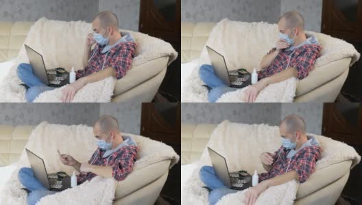 一名男子戴着防护面具坐在沙发上，通过视频链接向医生咨询如何治疗这种疾病。高清在线视频素材下载