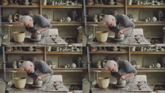 熟练的老陶工在工作场所的转轮上制作陶瓷壶。创作工艺，传统陶艺，趣味爱好理念。高清在线视频素材下载