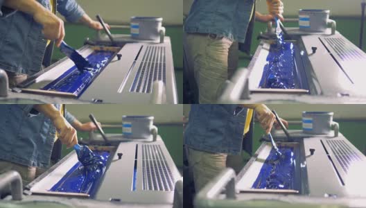 男工人甚至用刷子在机器的一个特殊部位刷上一层蓝色油漆。4 k。高清在线视频素材下载