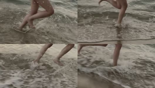 年轻女子的双腿在黎明时穿过大海高清在线视频素材下载