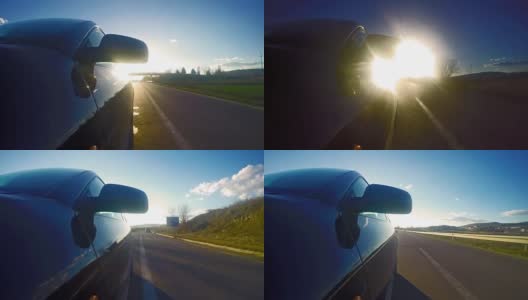 时间流逝的跑车正面视图行驶在狭窄的道路朝着阳光在日落，日出。UHD股票视频高清在线视频素材下载