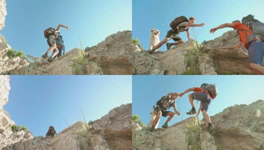 低角度的视频，儿子帮助他的父亲爬山的岩石高清在线视频素材下载
