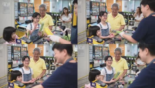 一名亚洲华人老人周末和他的孙女一起结帐和买杂货高清在线视频素材下载