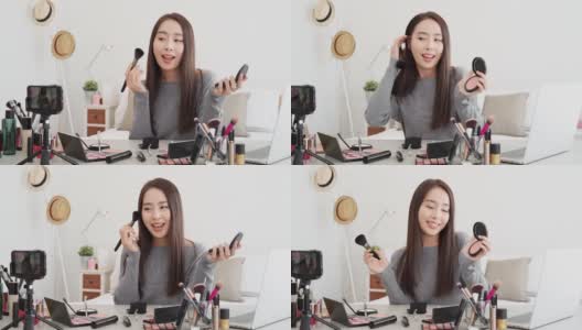 年轻美丽的亚洲女性专业美容视频博主做化妆品化妆教程在线直播在家通过手机高清在线视频素材下载
