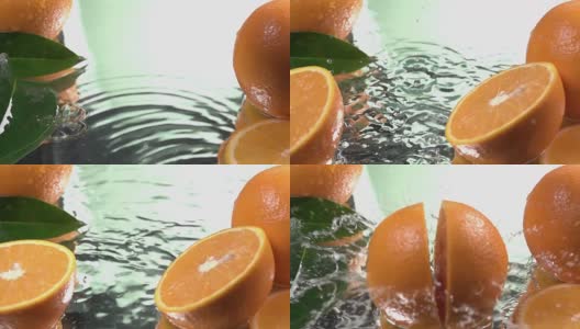 Orange hits orange juice surface and splits into halves. Slow motion shot高清在线视频素材下载
