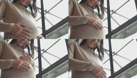 孕妇轻轻抚摸着肚子，怀孕/分娩高清在线视频素材下载