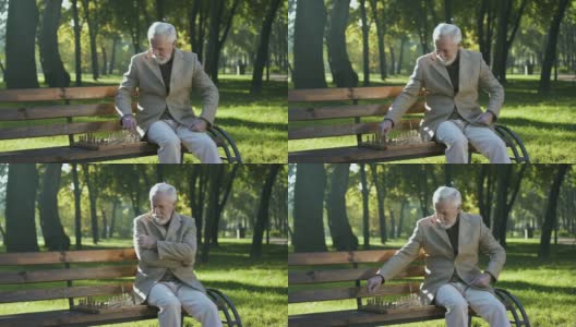 老人独自坐在公园长椅上下棋，退休福利多多高清在线视频素材下载
