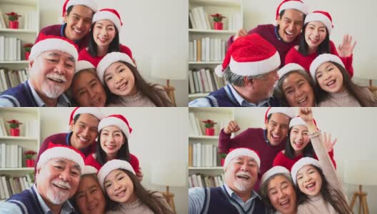来自不同群体的亚洲人聚集在一起庆祝圣诞节。头发花白的爷爷奶奶，兄弟姐妹，儿子，女儿参加家庭宴会，坐在自制的午餐桌旁，在冷杉树下交谈。高清在线视频素材下载