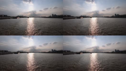 夕阳下的上海黄浦江上，大船身后的水迹与黄浦江上的上海城市地标剪影相呼应。慢镜头，4k镜头。高清在线视频素材下载