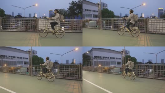 亚洲商人在立交桥上骑自行车高清在线视频素材下载