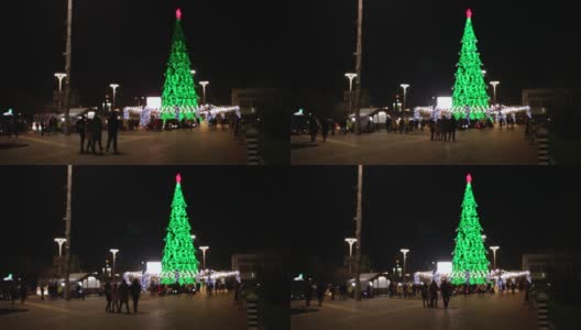 人们走在城市里，12月31日，新年，圣诞节。市中心有一棵大圣诞树，有花环和装饰品。节日心情无雪。散焦高清在线视频素材下载
